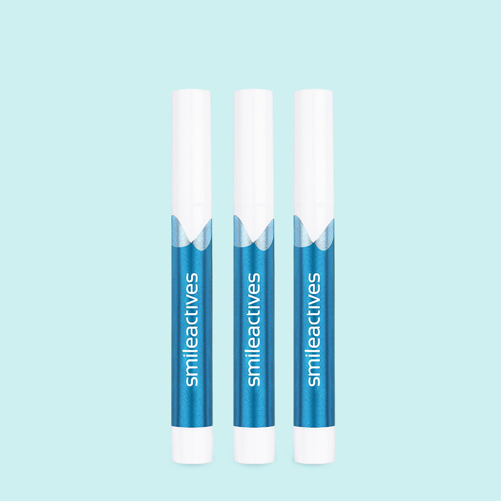 three smileactives whitening pens on a blue background
